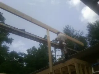 Carpenter setting a ridge beam over a new addition frame — Ice Dam Removal by Roofing Brothers in Harrington