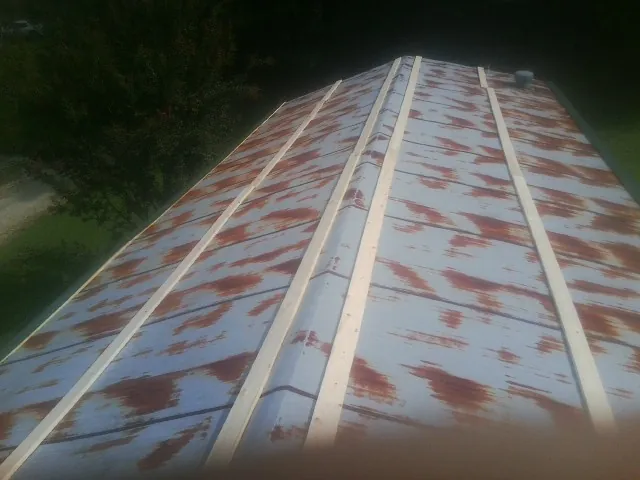Rusted metal roof panels with new wood purlins before replacement — Storm Damage Roof Repair in Harrington by Roofing Brothers